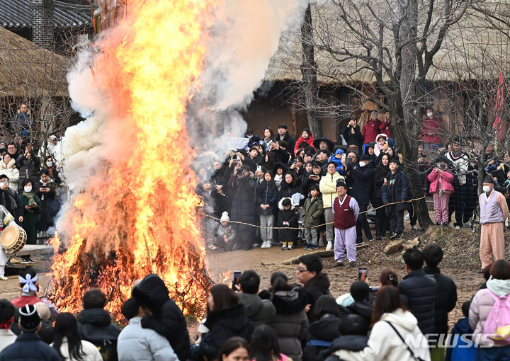 [용인=뉴시스] 김종택 기자 = 25일 경기도 용인시 한국민속촌에서 열린 정월대보름 달집태우기 행사에서 시민들이 활활 타오르는 달집을 바라보며 풍요와 무사안녕을 기원하고 있다. 2024.02.25. jtk@newsis.com