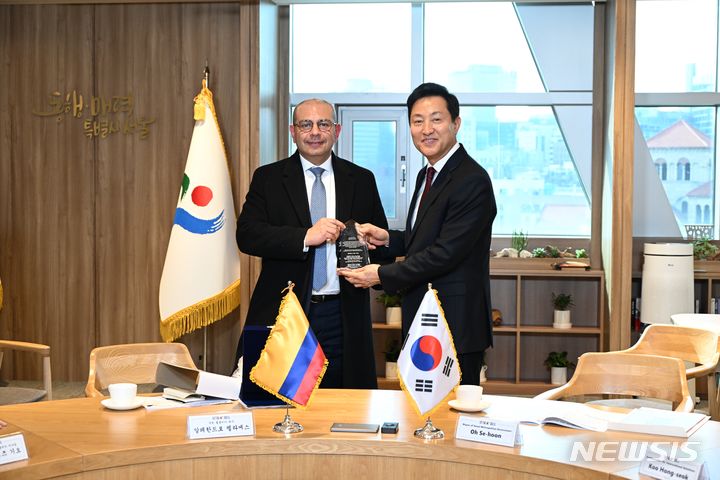 [서울=뉴시스] 오세훈 서울시장(오른쪽)이 26일 알레한드로 펠라에스 로드리게스 주한 콜롬비아 대사에게 감사패를 전달받고 있다.(제공=서울시)