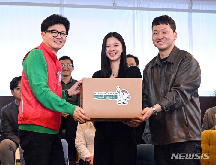 [서울=뉴시스] 추상철 기자 = 한동훈 국민의힘 비상대책위원장이 27일 서울 성동구의 한 북카페에서 기후 미래 스타트업 창업자들에게 '기후 미래 택배'를 전달하고 있다. (공동취재) 2024.02.27. photo@newsis.com