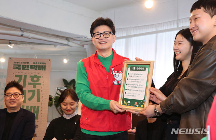 [서울=뉴시스] 추상철 기자 = 한동훈 국민의힘 비상대책위원장이 27일 서울 성동구의 한 북카페에서 기후 미래 스타트업 창업자들에게 '기후 미래 택배'를 전달한 후 기념촬영을 하고 있다. (공동취재) 2024.02.27. photo@newsis.com