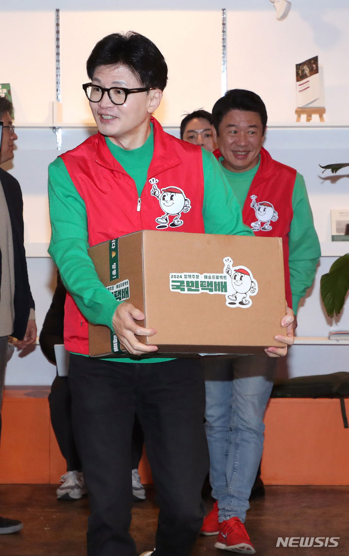 [서울=뉴시스] 추상철 기자 = 한동훈 국민의힘 비상대책위원장이 27일 오전 서울 성동구의 한 북카페에서 '기후 미래 택배' 상자를 들고 입장하고 있다. (공동취재) 2024.02.27. photo@newsis.com