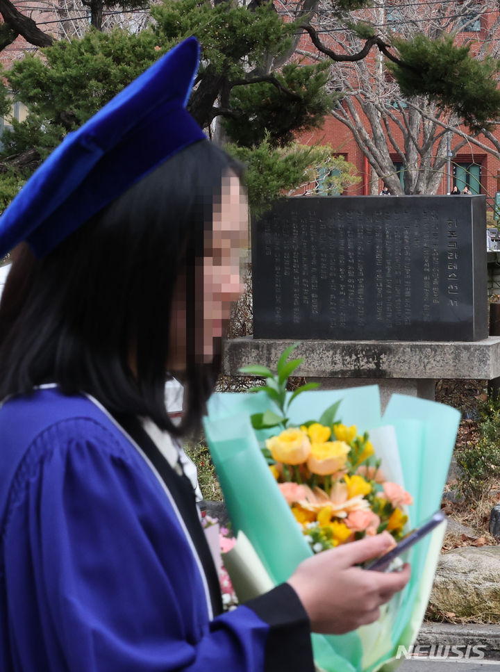 [서울=뉴시스] 최진석 기자 = 27일 서울 종로구 서울대학교 의과대학 행정관에서 열린 서울대 의대 2023학년도 전기 의과대학·대학원 학위수여식에 참석한 졸업생들이 히포크라테스가 말한 의학 윤리를 담고 있는 히포크라테스 선서문이 담겨진 비석 앞을 지나고 있다. 2024.02.27. myjs@newsis.com