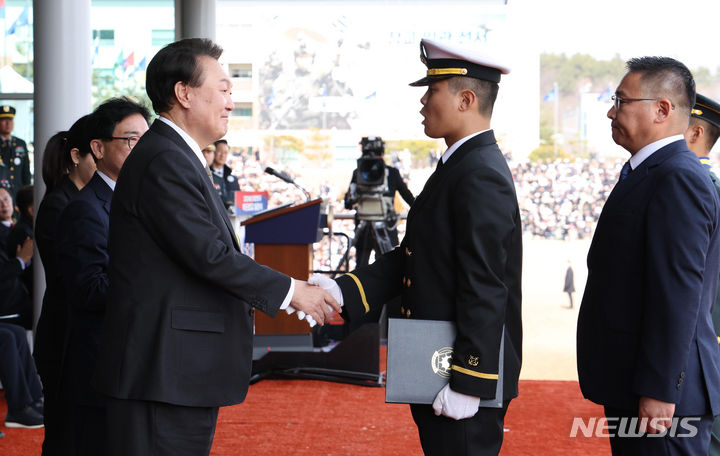 [괴산=뉴시스] 조수정 기자 = 윤석열 대통령이 28일 충북 괴산군 육군학생군사학교에서 열린 2024년 학군장교 임관식에서 해군 오지윤 소위에게 우등상을 수여한 뒤 악수하고 있다. 2024.02.28. chocrystal@newsis.com