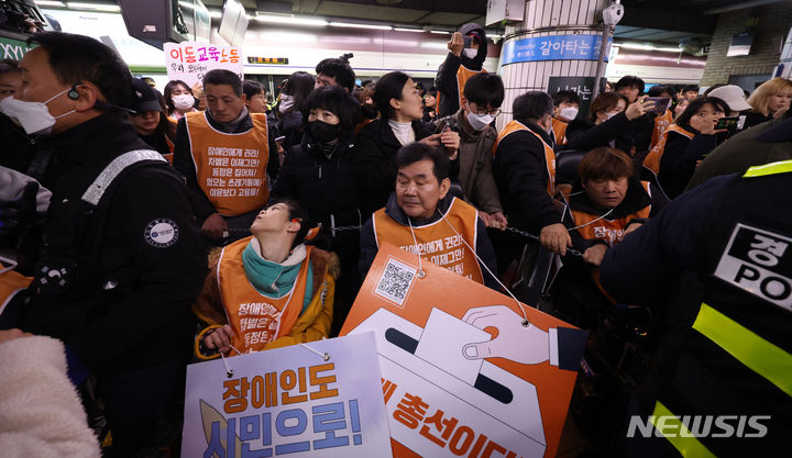 [서울=뉴시스] 김선웅 기자 = 전국장애인차별철폐연대(전장연) 및 관계단체가 29일 지하철1호선 서울역 승강장에서 장애인 이동권 보장을 촉구하고 있다. 2024.02.29. mangusta@newsis.com