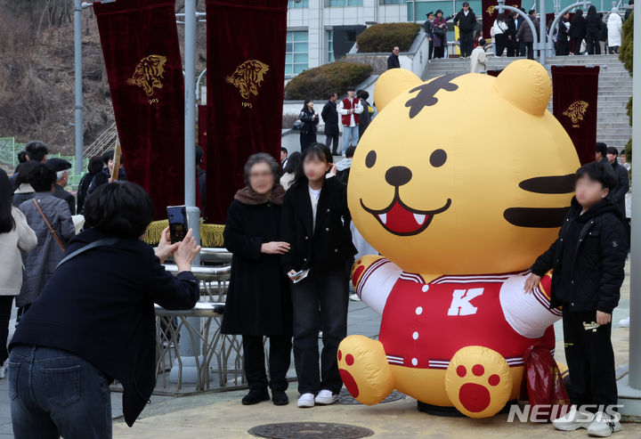 [서울=뉴시스] 조성우 기자 = 29일 오전 서울 성북구 고려대학교 화정체육관에서 열린 2024학년도 입학식에서 한 신입생이 가족과 사진을 찍고 있다. 2024.02.29. xconfind@newsis.com