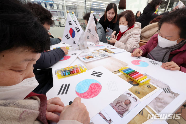[서울=뉴시스] 조성우 기자 = 29일 오후 서울 은평구 명예도로 '권애라로'에서 열린 진관사 태극기 그리기 행사에서 시민들이 태극기를 그리고 있다. 2024.02.29. xconfind@newsis.com