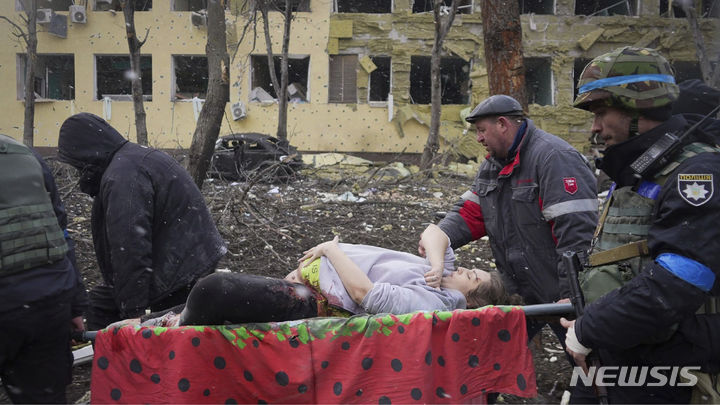 [AP/뉴시스] 영화 '마리우폴에서의 20일' 장면으로, 우크라이나 응급 구조대원과 자원봉사자들이 2022년 3월9일 공습 피해를 입은 마리우폴의 산부인과 병원에서 임신부를 옮기는 모습. 2024.03.12.