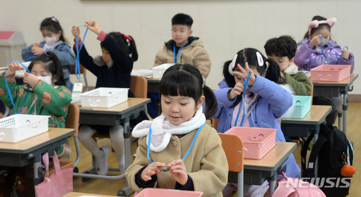 [전주=뉴시스] 김얼 기자 = 전국적으로 초등학교 입학식이 열린 4일 전북 전주시 전주양현초등학교에서 1학년 입학생들이 명찰을 착용해보고 있다. 2024.03.04. pmkeul@newsis.com