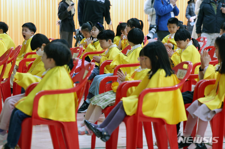 [서울=뉴시스] 고승민 기자 = 4일 서울 광진구 성자초등학교에서 열린 입학식에서 노란 가운을 입은 신입생들이 박수를 치고 있다. 2024.03.04. kkssmm99@newsis.com