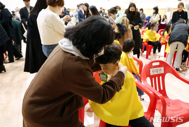 [서울=뉴시스] 고승민 기자 = 4일 서울 광진구 성자초등학교에서 열린 입학식에서 학부모들이 자녀에게 명찰을 걸어주고 있다. 2024.03.04. kkssmm99@newsis.com