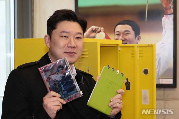 [서울=뉴시스] 권창회 기자 = 한국인 올림픽 최다 메달 보유 선수 진종오가 4일 오후 서울 성동구 브리온 성수에서 열린 은퇴식에서 선수 생활중 의미있는 물품인 노트를 꺼내보이고 있다. 2024.03.04. kch0523@newsis.com