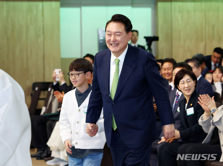 [대구=뉴시스] 전신 기자 = 윤석열 대통령이 4일 대구 북구 엑스코에서 열린 제4회 국립공원의 날 및 팔공산 국립공원 승격 기념식에서 기념 퍼포먼스를 위해 한 학생의 손을 잡고 무대로 향하고 있다. 2024.03.04. photo1006@newsis.com
