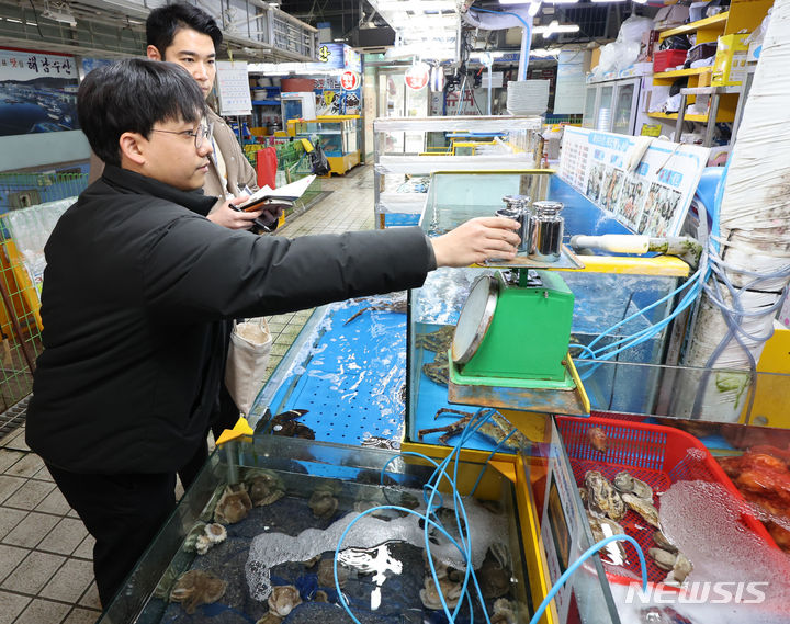 [인천=뉴시스] 전진환 기자 = 5일 오후 인천 남동구 소래포구종합어시장에서 남동구합동점검반이 무게추를 이용해 상인들이 사용하는 접시 형태 저울을 점검하고 있다. 2024.03.05. amin2@newsis.com