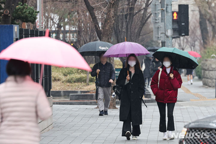 [서울=뉴시스] 권창회 기자 = 화요일인 오는 12일은 전국 대부분 지역에서 비 또는 눈이 내리겠다. 특히 내일 저녁에는 돌풍과 함께 천둥·번개가 치는 곳이 있겠으니 안전에 유의해야 한다.  사진은 지난 7일 오후 서울 시내 거리에서 시민들이 우산을 쓰고 이동하는 모습. 2024.03.07. kch0523@newsis.com