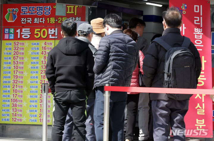 [서울=뉴시스] 서울의 한 복권판매점에서 고객들이 줄지어 복권 구입을 기다리고 있다. (사진=뉴시스DB)