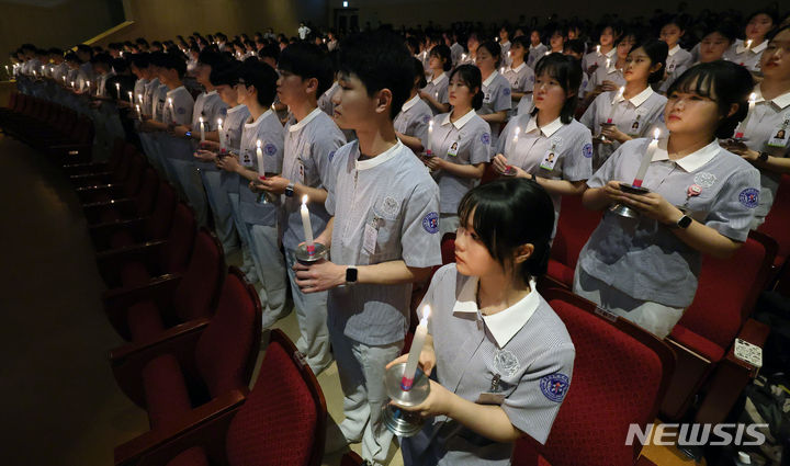 [대구=뉴시스] 이무열 기자 = 8일 대구 달서구 계명대학교 간호대학 존슨홀에서 열린 ‘2024학년도 나이팅게일 선서식’에서 간호대학 학생들이 촛불을 들고 나이팅게일의 숭고한 희생정신을 본받아 전문 간호인으로서 최선을 다할 것을 다짐하고 있다. 2024.03.08. lmy@newsis.com