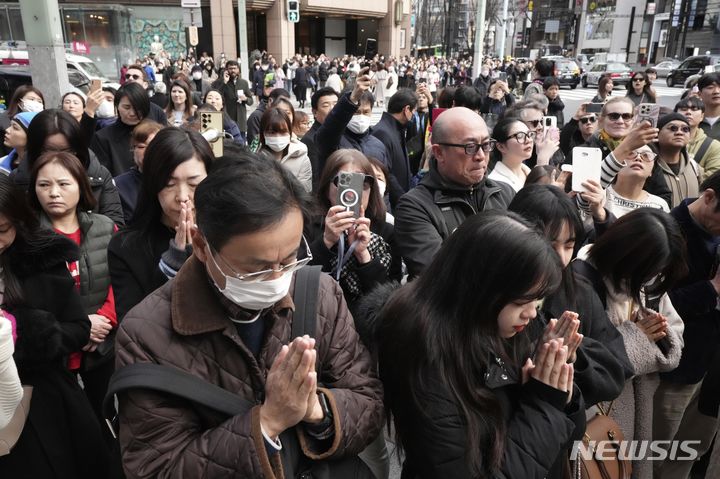 [도쿄=AP/뉴시스]2011년 동일본대지진이 발생한지 11일 13년이 지났다. 그럼에도 불구하고 약 3만 명이 여전히 피난 중이며 후쿠시마(福島) 제1 원자력발전소 폐로도 불투명하다고 현지 언론들이 전했다. 사진은 이날 오후 2시46분께 일본 동일본대지진 13주기를 맞아 도쿄에서 지진 희생자들을 위한 묵념이 시작되자 군중들이 손을 모으고 기도하고 있는 모습. 2024.03.11.