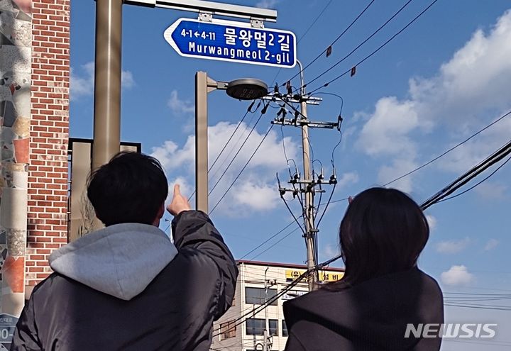 [전주=뉴시스]윤난슬 기자 = 전북 전주시에 설치된 도로명판을 시민들이 쳐다보고 있다. (사진=전주시 제공)