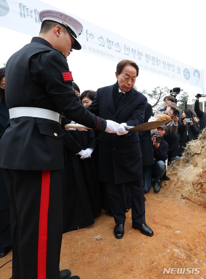 [서울=뉴시스] 최진석 기자 = 김현철 김영삼대통령기념재단 이사장이 11일 오전 서울 동작구 국립서울현충원 김영삼 전 대통령묘소에서 어머니인 김 전 대통령의 부인 고 손명순 여사의 하관을 마친 후 취토하고 있다. 2024.03.11. myjs@newsis.com
