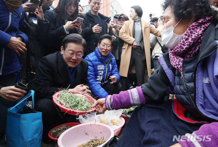 [충남=뉴시스] 고범준 기자 = 이재명 더불어민주당 대표가 11일 충남 홍성군 홍성시장을 방문해 봄나물을 구매하고 있다. (공동취재) 2024.03.11. photo@newsis.com