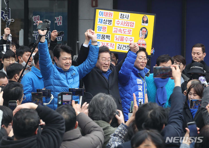 [충남=뉴시스] 고범준 기자 = 이재명 더불어민주당 대표가 11일 충남 홍성군 홍성시장을 방문해 복기왕 충남 아산시갑 국회의원 후보와 양승조 홍성·예산 국회의원 후보의 손을 들어 올리고 있다. (공동취재) 2024.03.11. photo@newsis.com