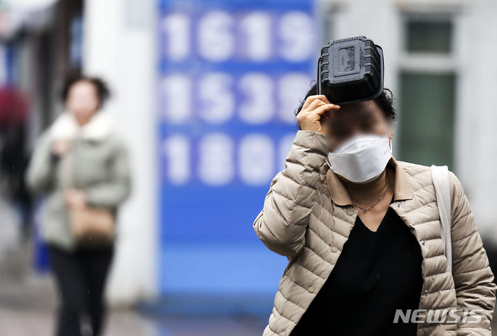 [서울=뉴시스] 정병혁 기자 = 비가 내리고 있는 12일 서대문구 홍제역 인근에서 한 시민이 비를 피해 이동하고 있다. 2024.03.12. jhope@newsis.com