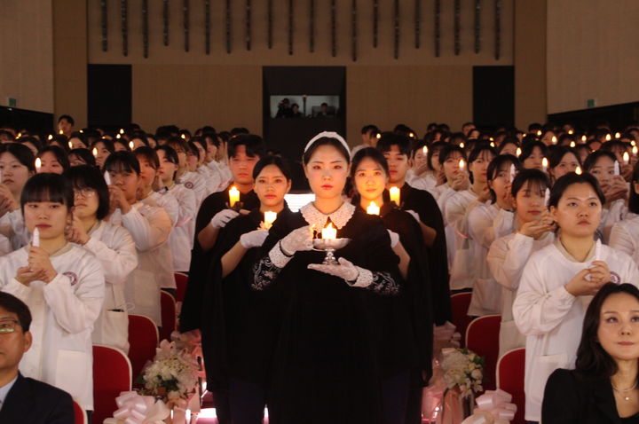 대구과학대학교에서 13일 거행된 제62회 나이팅게일 선서식에서 나이팅게일(간호학과 4학년 은하주)이 선서생들에게 촛불을 밝혀주며 입장하고 있다.  *재판매 및 DB 금지