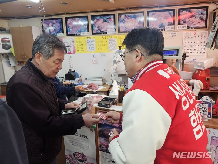 [서울=뉴시스] 서울 마포을에 출마하는 함운경 국민의힘 후보가 13일 서울 마포구 성산동 일대 상가에서 주민들과 인사를 나누고 있다. (사진 = 함 후보 측 제공) 2024.03.13. photo@newsis.com