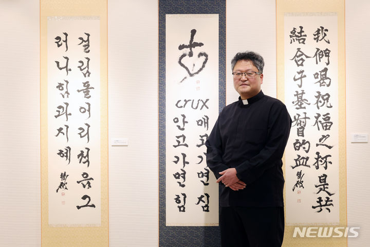 [서울=뉴시스] 박진희 기자 = 정성훈 파비아노 신부가 지난 13일 서울 명동대성당 지하 전시장인 '갤러리 1898'에서 뉴시스 인터뷰 앞서 사진 촬영을 하고 있다. 서예가 정 신부를 비롯한 한만옥 토마스 신부, 남덕희 베드로 신부, 용하진 실바노 신부, 도현우 안토니오 신부 5명의 사제들은 '십자가 영성'을 주제로 지난 13일부터 합동 서예 전시회를 하고 있다. 2024.03.16. pak7130@newsis.com
