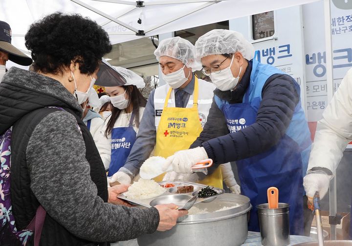 대한적십자사 대구지사 박명수 회장, 대한적십자사봉사회 대구달성군지구협의회 박연근 회장, DGB대구은행 대구4본부 박영삼 본부장 등이 대구달서구 두류공원에서 진행된 무료급식 행사에서 배식하고 있다. *재판매 및 DB 금지