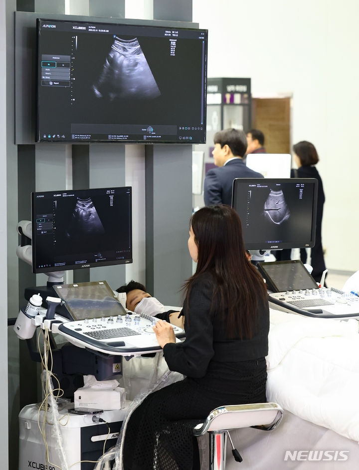 [서울=뉴시스] 황준선 기자 =지난 2024년 3월 14일 서울 강남구 코엑스에서 열린 제39회 국제의료기기·병원설비 전시회(KIMES 2024)에서 관람객이 초음파 검사 장비를 체험하고 있다. 2024.03.14. hwang@newsis.com