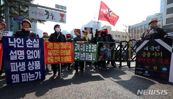 [서울=뉴시스] 김금보 기자 = 홍콩H지수(항셍중국기업지수) 기초 주가연계증권(ELS) 피해자 모임 회원들이 15일 오후 서울 중구 NH농협은행 앞에서 열린 '대국민 금융 사기 규탄 집회'에서 투자 원금 전액 배상 등 계약 무효를 촉구하는 피켓을 들고 있다. 2024.03.15. kgb@newsis.com