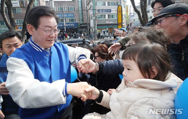 [용인=뉴시스] 조성봉 기자= 이재명 더불어민주당 대표가 16일 경기 용인시 수지구청역 인근에서 어린이와 인사를 나누고 있다. (공동취재)2024.03.16. photo@newsis.com