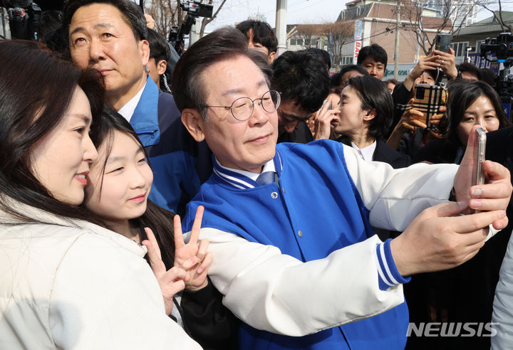 [용인=뉴시스] 조성봉 기자= 이재명 더불어민주당 대표가 16일 경기 용인시 수지구청역 인근에서 시민들과 셀카를 찍고 있다.(공동취재)2024.03.16. photo@newsis.com