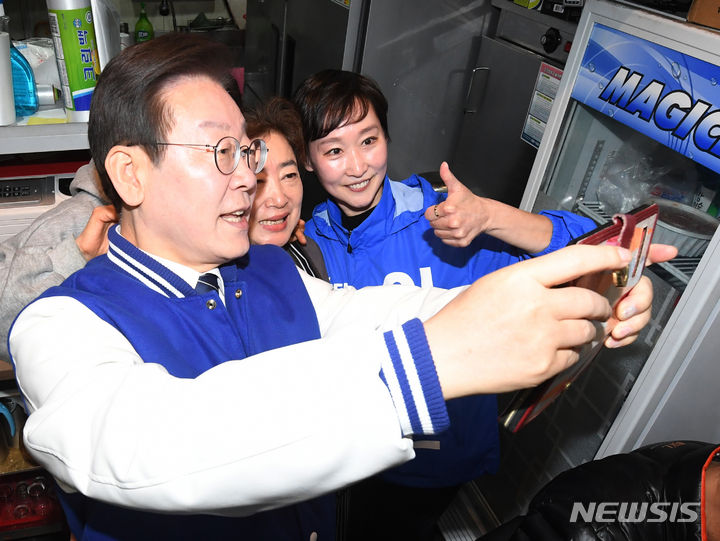 [서울=뉴시스] 이재명 더불어민주당 대표가 19일 선거 유세를 이유로 예정된 대장동 재판에 불출석하면서 재판이 연기됐다. 사진은 이 대표가 지난 18일 서울 마포구 경의선숲길을 방문해 시민들과 기념촬영을 하고 있다. (공동취재) 2024.03.18. photo@newsis.com