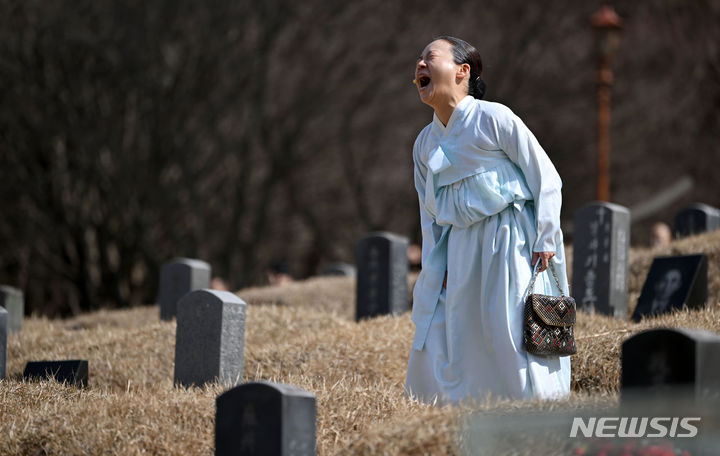 [광주=뉴시스] 이영주 기자 = 19일 오전 광주 북구 망월동 5·18구묘역에서 제44주기 5·18민중항쟁기념행사위원회가 준비중인 전야제 주제공연 '언젠가 봄날에 우리 다시 만나리'가 공연되고 있다. 5·18 유족으로 분장한 연기자가 자식을 잃은 심정을 연기하며 울분을 쏟아내고 있다. 2024.03.19. leeyj2578@newsis.com