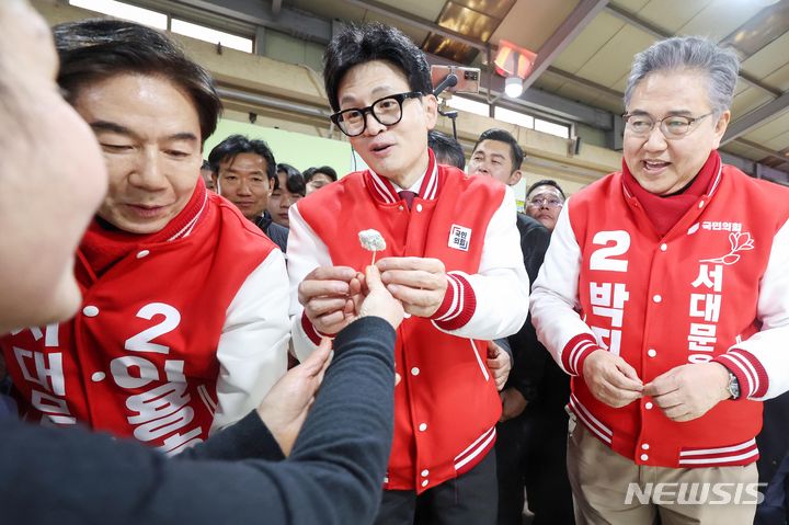 [서울=뉴시스] 고범준 기자 = 한동훈 국민의힘 총괄선대위원장이 19일 오후 서울 서대문구 인왕시장에 이용호 서대문갑·박진 서대문을 후보와 함께 방문해 상인으로부터 떡을 전달받고 있다. (공동취재) 2024.03.19. photo@newsis.com