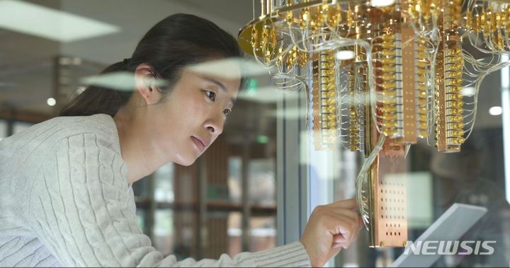 [서울=뉴시스]한국표준과학연구원(KRISS) 연구원이 양자컴퓨터를 살펴보고 있다. (사진=KRISS 제공)