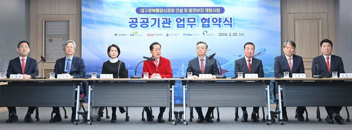 [대구=뉴시스] 홍준표 대구시장(사진 가운데 빨간 상의)이 20일 오전 10시 대구시청 산격청사에서 국민의힘 주호영(대구 수성갑, 사진 왼쪽 1번째)·강대식(대구 동·군위을, 사진 오른쪽 1번째) 의원이 참석한 한국토지주택공사(사장 이한준), 한국공항공사(부사장 이미애), 대구도시개발공사(사장 정명섭), 대구교통공사(사장 김기혁), 경상북도개발공사(사장 이재혁)와 TK신공항 건설 및 종전부지 개발을 지원하기 위한 업무협약을 체결하고 있다(사진=대구시 제공) 2024.03.20. photo@newsis.com *재판매 및 DB 금지