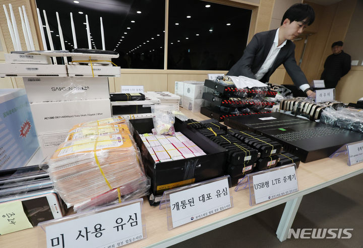 [서울=뉴시스] 김진아 기자 = 20일 오전 서울 송파구 서울동부지검에서 열린 '역대 최대규모 보이스피싱 발신번호 변작중계기 운영조직 적발' 브리핑에서 관계자가 압수물품을 정리하고 있다. 보이스피싱 범죄 정부합동수사단은 중국, 태국, 남아공 등 다국적 외국인으로 구성된 역대 최대규모의 보이스피싱 발신번호 변작중계기 운영조직을 적발, 단순 중계기 관리책뿐 아니라 간부급인 수당지급책, 부품보관소 관리책, 환전책 등 총 21명을 검거하여 구속기소 했다고 밝혔다. 2024.03.20. bluesoda@newsis.com