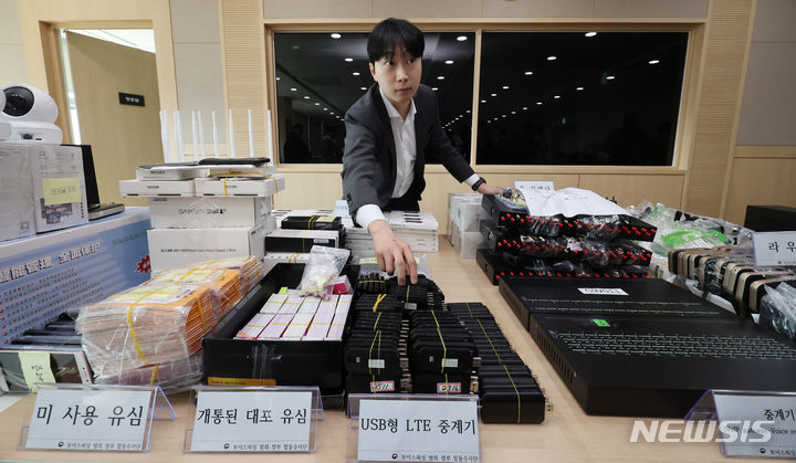 [서울=뉴시스] 김진아 기자 = 20일 오전 서울 송파구 서울동부지검에서 열린 '역대 최대규모 보이스피싱 발신번호 변작중계기 운영조직 적발' 브리핑에서 관계자가 압수물품을 정리하고 있다. 보이스피싱 범죄 정부합동수사단은 중국, 태국, 남아공 등 다국적 외국인으로 구성된 역대 최대규모의 보이스피싱 발신번호 변작중계기 운영조직을 적발, 단순 중계기 관리책뿐 아니라 간부급인 수당지급책, 부품보관소 관리책, 환전책 등 총 21명을 검거하여 구속기소 했다고 밝혔다. 2024.03.20. bluesoda@newsis.com