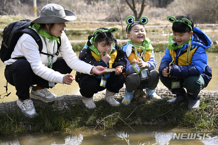 [광주=뉴시스] 박기웅 기자 = 20일 '람사르습지 등록 기원 탐사대'에 참여한 아이들이 광주 북구 평두메습지에서 올챙이와 개구리를 찾아보며 즐거워하고 있다. 광주 북구는 평두메습지가 국내 26번째 람사르습지로 등록될 수 있도록 다양한 활동을 추진 중이다. 2024.03.20. pboxer@newsis.com