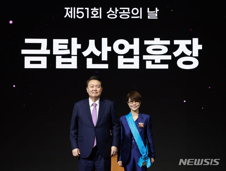[서울=뉴시스] 전신 기자 = 윤석열 대통령이 20일 서울 영등포구 63컨벤션센터에서 열린 제51회 상공의 날 기념식에서 이영희 삼성전자 사장에게 금탑산업훈장을 수여한 뒤 기념촬영하고 있다. (대통령실통신사진기자단) 2024.03.20. photo1006@newsis.com