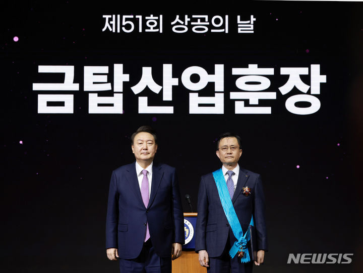 [서울=뉴시스] 전신 기자 = 윤석열 대통령이 20일 서울 영등포구 63컨벤션센터에서 열린 제51회 상공의 날 기념식에서 신영환 대덕전자 대표이사에게 금탑산업훈장을 수여한 뒤 기념촬영하고 있다. (대통령실통신사진기자단) 2024.03.20. photo1006@newsis.com