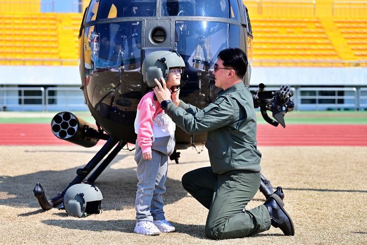 [논산=뉴시스] 헬기전시회가 열린 논산시민운동장에서 한 조종사가 어린이에게 조종 헬멧을 씌워주고 있다. (사진=뉴시스 DB). photo@newsis.com *재판매 및 DB 금지