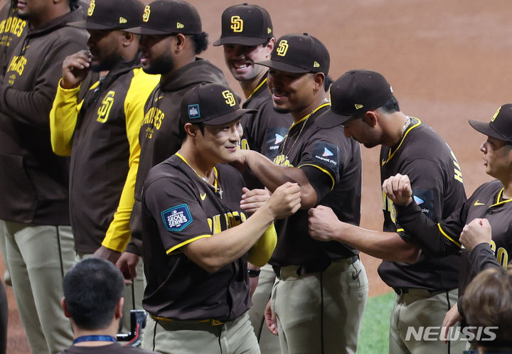 [서울=뉴시스] 김선웅 기자 = 21일 서울 구로구 고척스카이돔에서 열린 2024 미국 메이저리그(MLB) 월드투어 서울시리즈 공식 개막전 샌디에이고 파드리스와 LA 다저스의 2차전 경기, 샌디에이고 김하성이 그라운드에 입장하며 동료들과 주먹을 맞대고 있다. 2024.03.21. mangusta@newsis.com