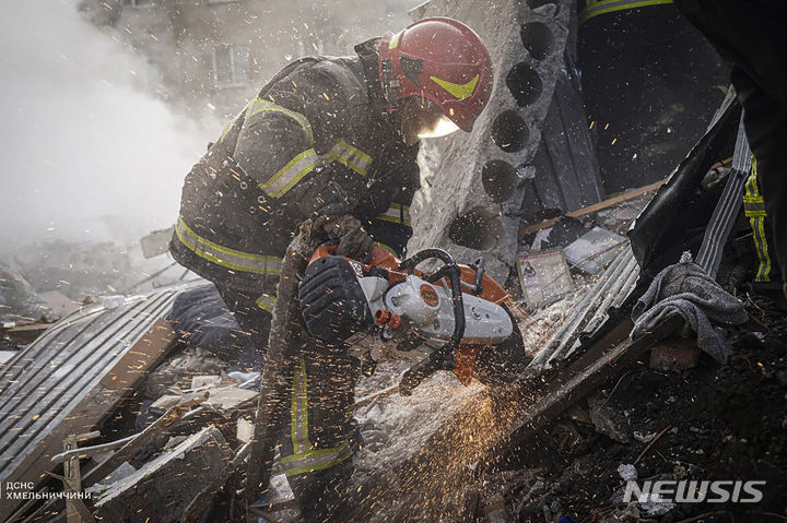 [흐멜니츠키( 우크라이나)=AP/뉴시스]올해 3월 22일 러시아의 공습으로 파괴된 서부 흐멜니츠키 시내에서 긴급구조대가 무너진 건물 속 피해자를 구하기 위해 철판을 뚫는 작업을 진행하고 있다.( 우크라이나 비상대책본부 제공사진). 2024. 04. 16. 
