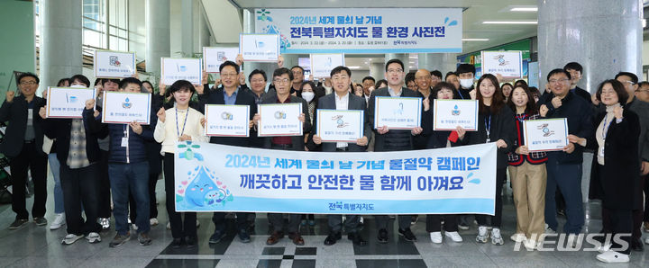 [전주=뉴시스] 22일 전북도청 로비에서 열린 2024 년 세계 물의 날 기념행사에 김관영 전북지사를 비롯한 청원들이 물의 소중함을 일깨우고 모두의 물절약 실천 동참을 위한 열린 캠페인을 하며 기념촬영을 하고 있다. 2024.03.22 (사진= 전북자치도 제공) *재판매 및 DB 금지