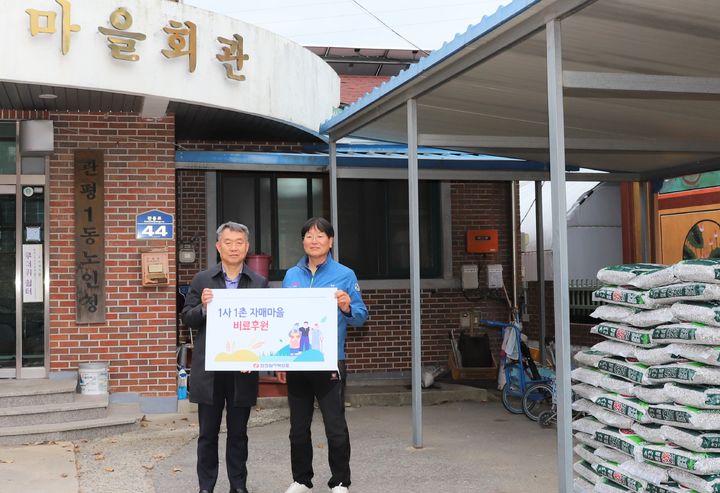 [대전=뉴시스] 22일 한전원자력연료 이선남(왼쪽) 소통협력실장이 1사1촌 자매마을을 찾아 비료 전달식을 갖고 김기성 관평동 통장과 기념촬영을 하고 있다.(사진=한전원자력연료 제공) *재판매 및 DB 금지