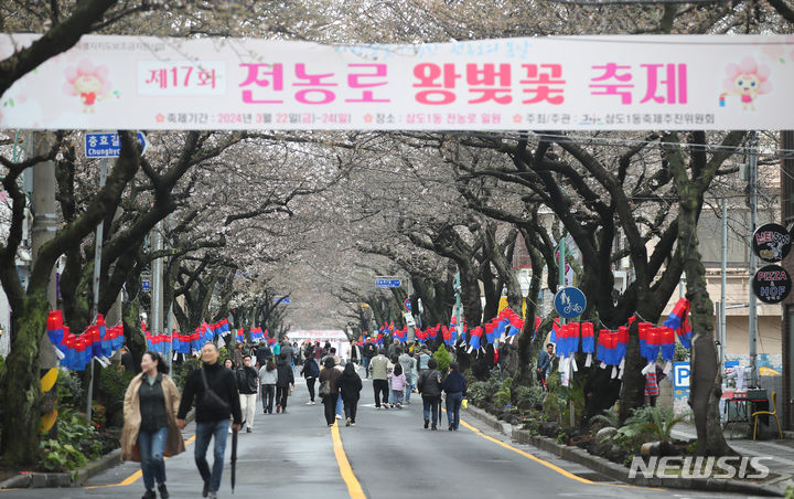 [제주=뉴시스] 우장호 기자 = 흐린 날씨를 보인 24일 오후 제주 도내 대표적인 벚꽃 명소인 제주시 전농로 일원을 찾은 가족과 친구, 연인들이 봄기운을 만끽하고 있다. 2024.03.24. woo1223@newsis.com